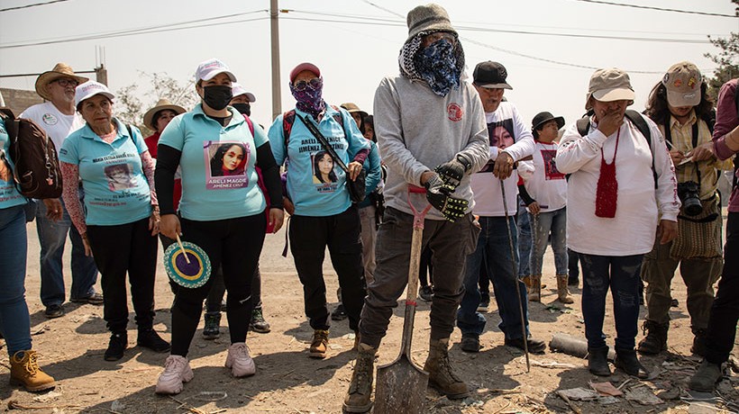 A group of people stand in the sun. 