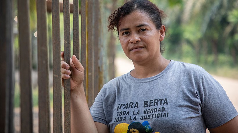 A woman holding a metal fence