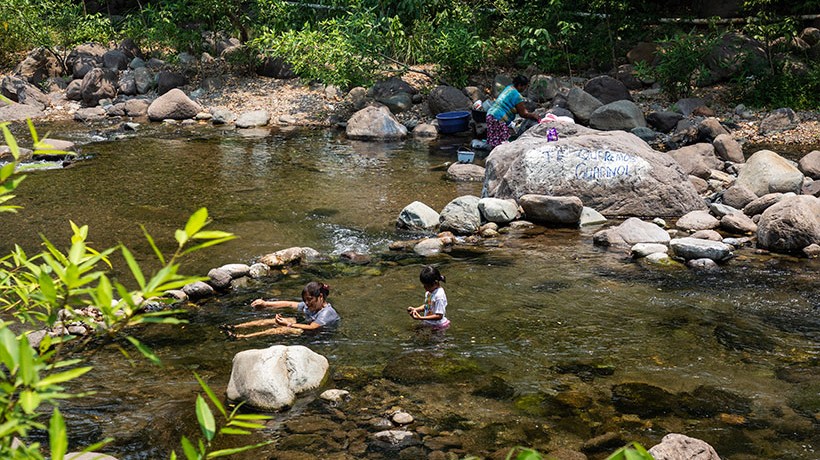 A woman and a girl swim in a river