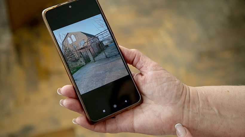 Precious memories. Lina shows a picture of her house in the occupied city of Zaporizhzhia. Refugees and displaced people carry with them memories of how life was before the war. © Vincent Tremeau/OHCHR