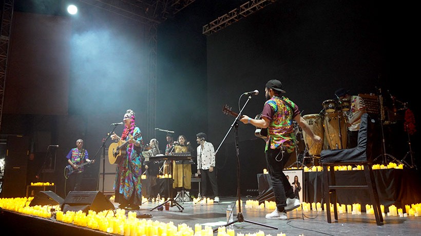 People in a candlelit scenario singing and playing instruments.