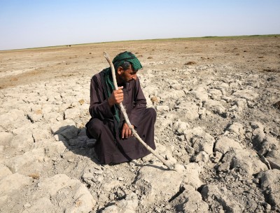 رجل من عرب الأهوار ينظر إلى أرض جافة قاحلة كانت في السابق مغمورة بالمياه بالقرب من الجبايش جنوب العراق © رويترز