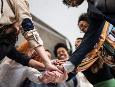 Group of people with stacked hands. © FG Trade / Getty Images