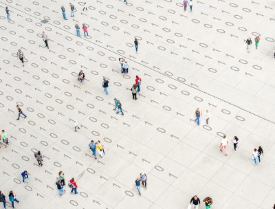 Crowd walking over binary code © Getty Images/Orbon Alija