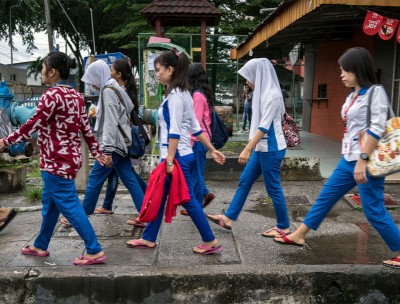 A group of young women migrant workers make their way through back alleys to get to work at a nearby hi-tech factory facility, Petaling Jaya, Malaysia, 28 November 2017. © UN Women