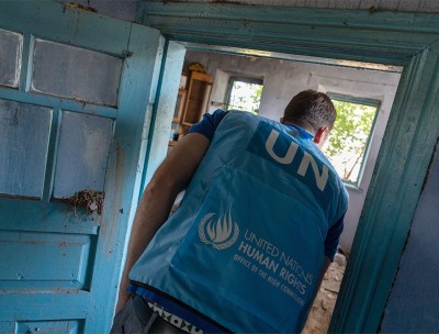 A UN Human Rights officer surveys a destroyed home in a village that was occupied by Russian troops before it was recaptured by Ukraine. © Vincent Tremeau/OHCHR