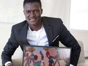Games designer Lual Mayen poses with a screenshot of one of his games depicting life as a refugee. ©Lual Mayen