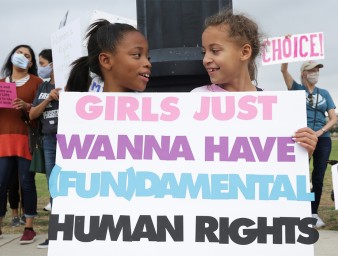 Two girls hold a sign as supporters of women's reproductive rights take part in Women's March in Texas. © Credit – ©REUTERS/Shelby Tauber