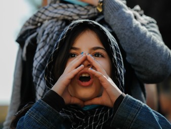 Cover photo of un Human Rights Annual Appeal 2023. A young girl wearing a headscarf cups her hands around her mouth as she shouts during a protest in Beirut, Lebanon, 10 February 2021 © Florient Zwein/Reuters 