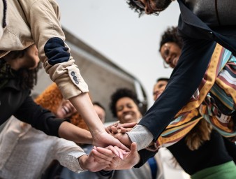 Group of people with stacked hands. © FG Trade / Getty Images