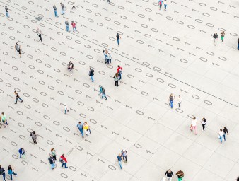 Crowd walking over binary code © Getty Images/Orbon Alija