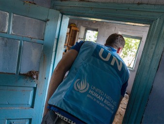 A UN Human Rights officer surveys a destroyed home in a village that was occupied by Russian troops before it was recaptured by Ukraine. © Vincent Tremeau/OHCHR