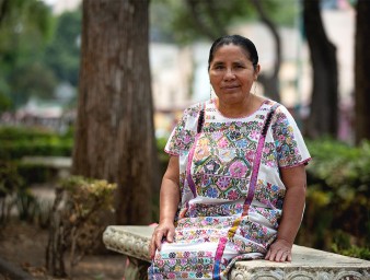 A woman sitting down on a bench in a park.