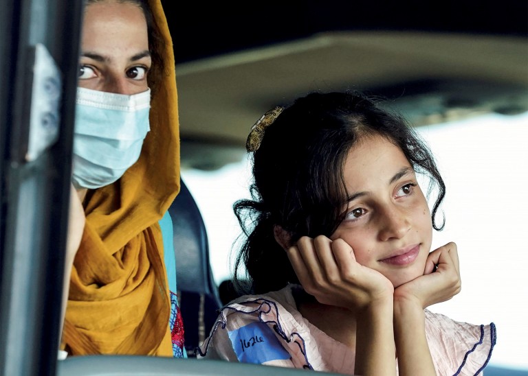 A mother wearing a mask with her daughter